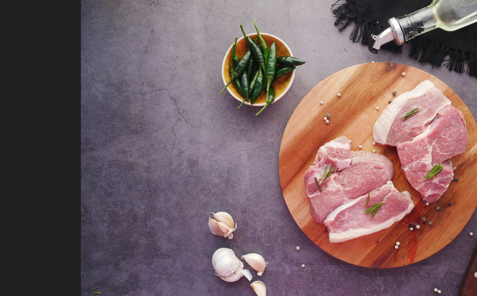 Top view of raw meat on chopping board on black background